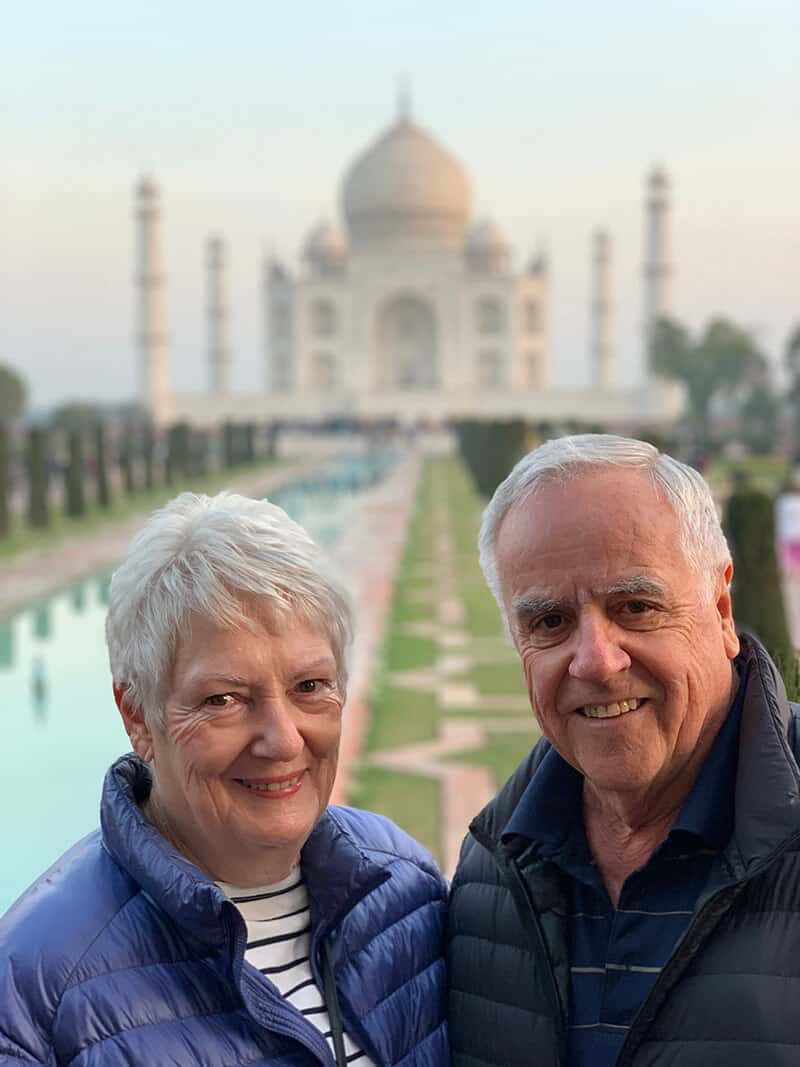 couple standing with Taj Mahal in background