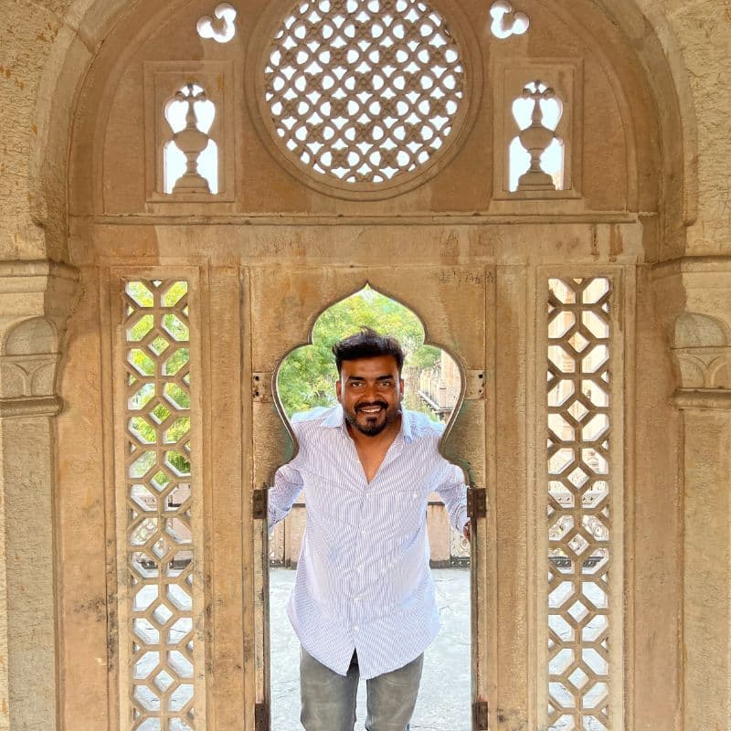 India man standing in arch of marble door