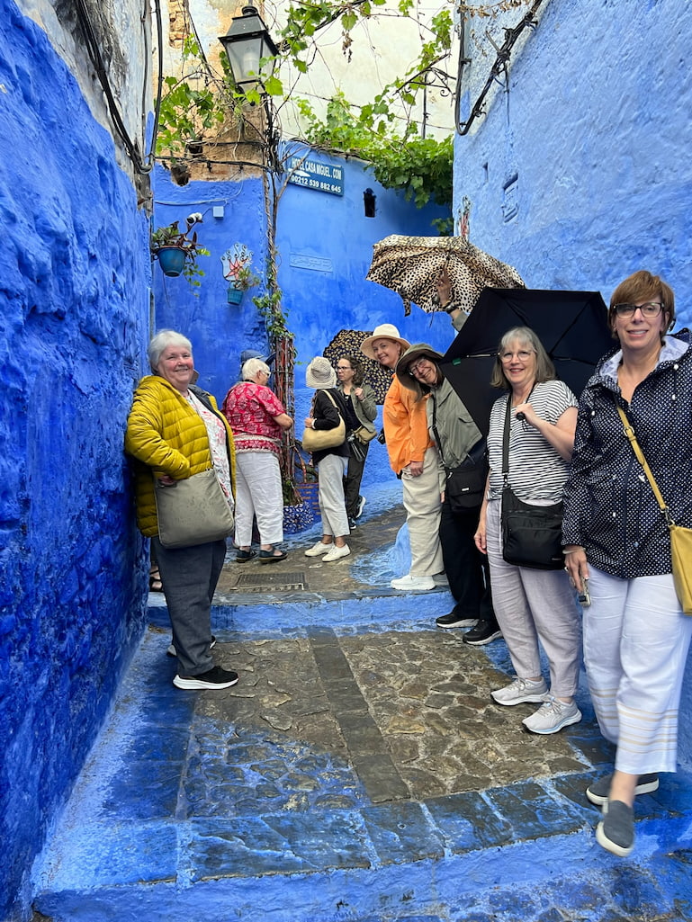 tour group of people standing in bright blue laneway