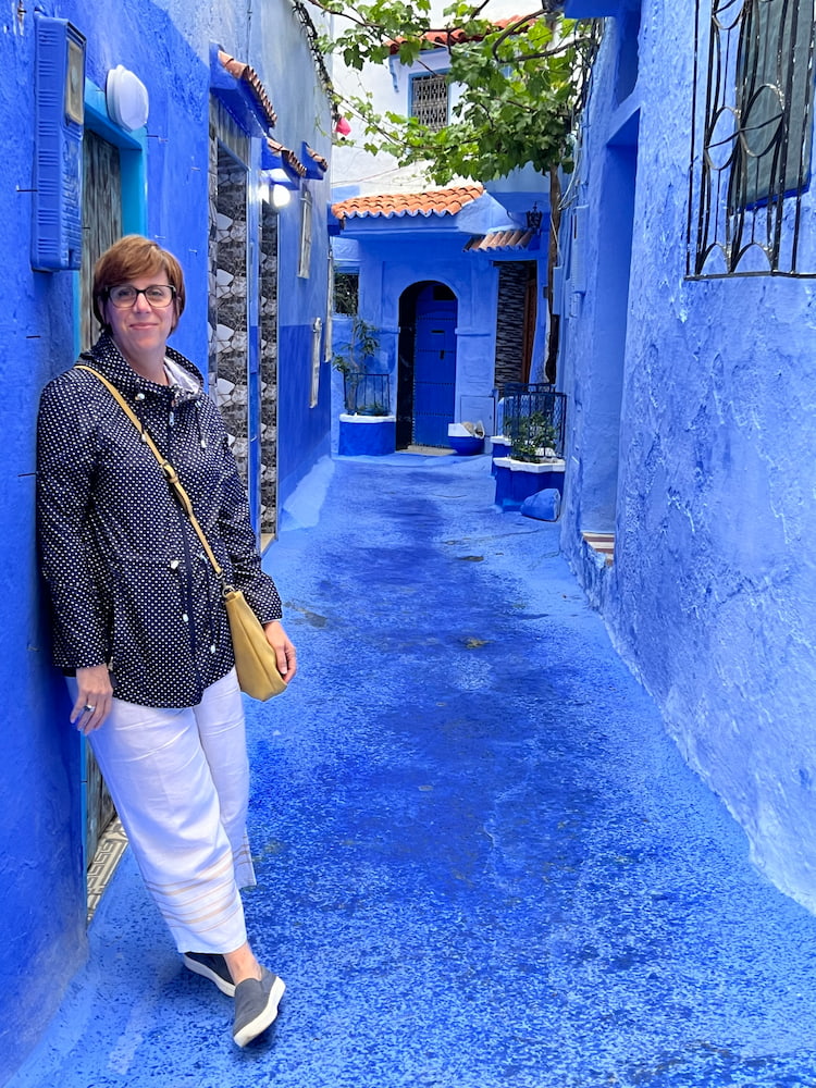 lady standing in bright blue alleyway 