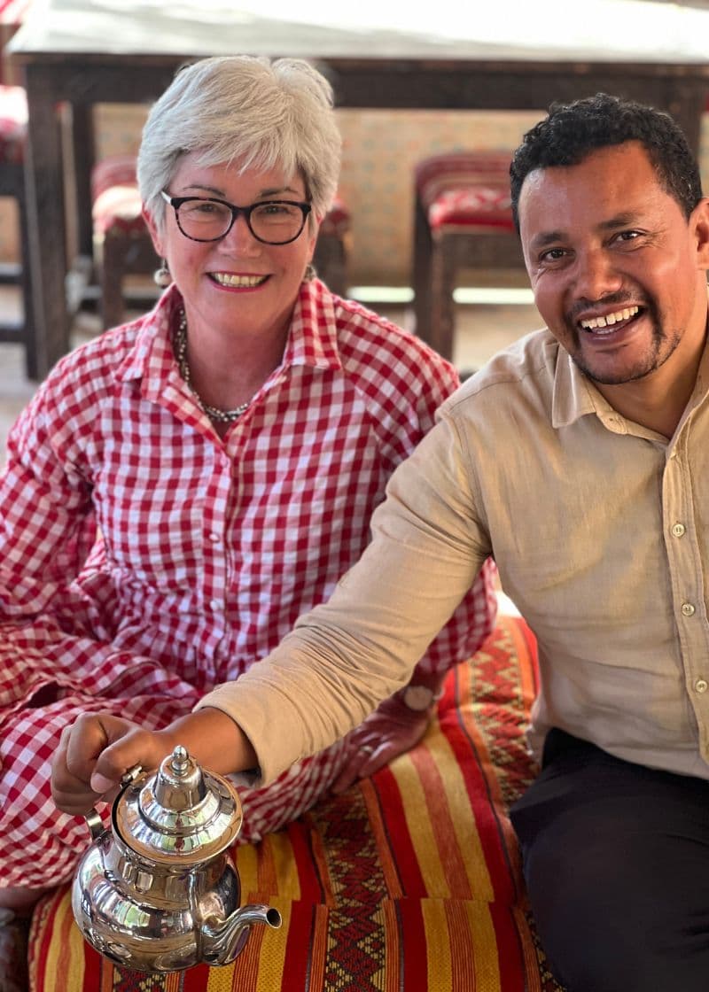 Moroccan guide pouring tea with tourist