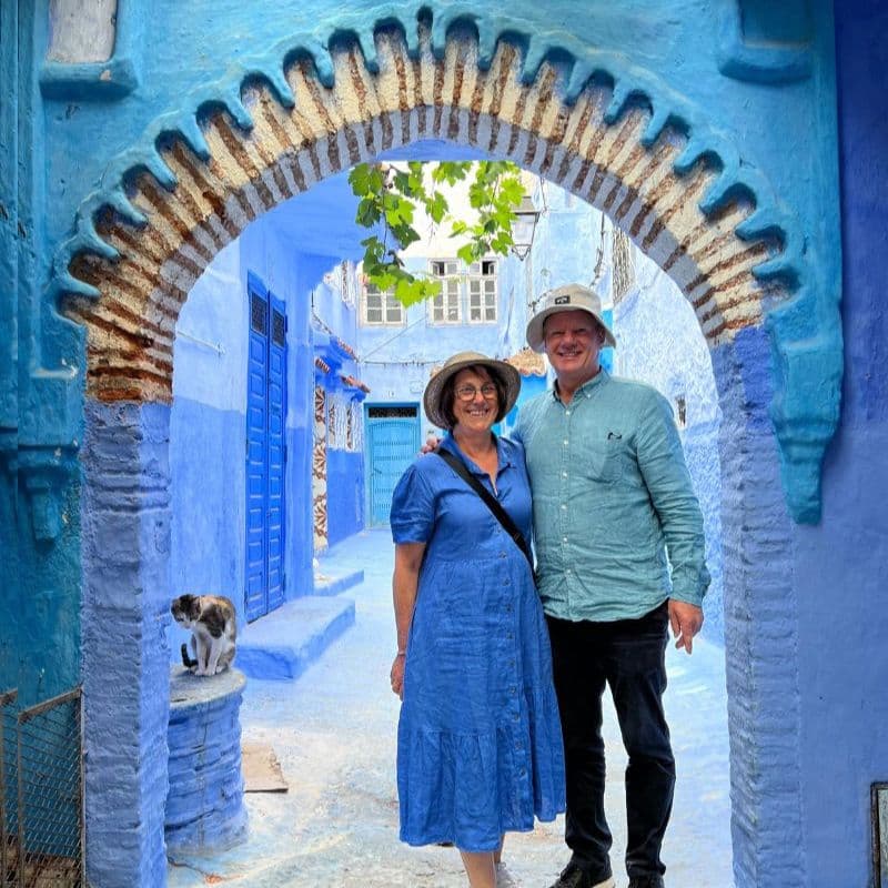 couple standing in blue arch