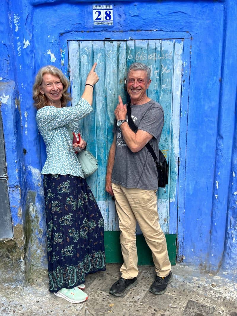 couple pointing to number 28 above a blue door