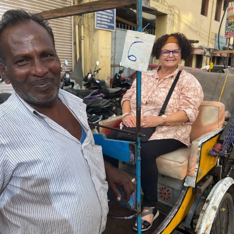 tourist sitting in cycle rickshaw with Indian driver