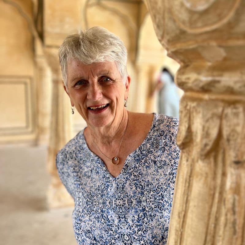 lady smiling standing next to marble pillar at Amber Fort